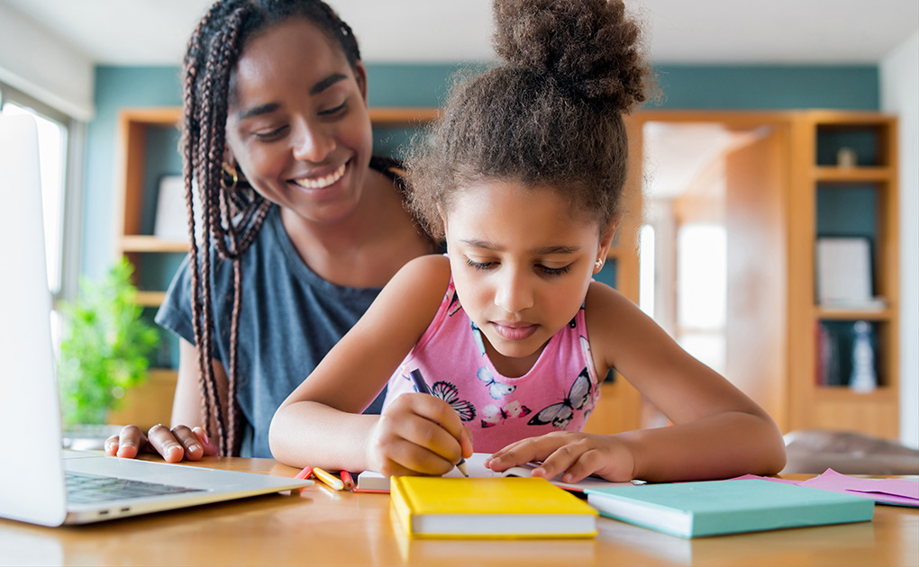 Woman sitting at a desk with a young girl