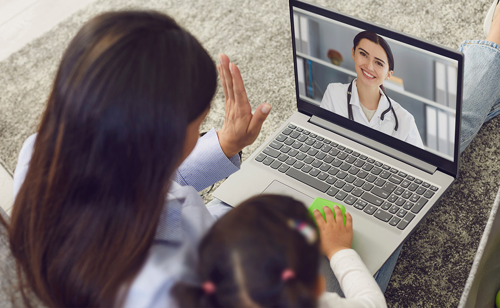 mother and young daughter on video call with provider